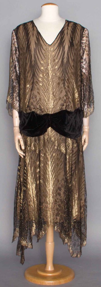 GOLD & BLACK LACE EVENING GOWN, c. 1922: Lace & lame in frond pattern, black velvet hip sash, long sleeves, V-neck, handkerchief hem, H 40", L 51", (few breaks in chiffon backing) excellent; t/w 1 c. 1925 lame & velvet party dress, patterned