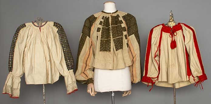 THREE EMBROIDERED BLOUSES, HUNGARY & ROMANIA, 1865-1915: 2 early 20th C Hungarian cream cotton w/ 3/4 length puff sleeves: 1 embroidered in orange & red wool; 1 embroidered in black w/ gold sequins; 1 late 19th C Romanian cotton w/ yellow & red stripes & me