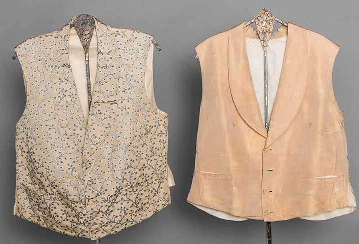 TWO GENT'S SILK VESTS, MID 19TH C: Both w/ shawl collars & 3 F pockets: 1 beige faille w/ tiny rosebud brocade, CH 42", L 20", (fabric worn at edges, especially under arms, 1 missing & 3 worn buttons) fair; 1 ivory faille w/ meandering