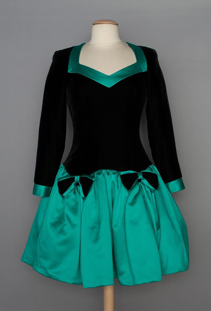 BILL BLASS EVENING DRESS, 1980s: Black velvet bodice fitted to hip w/ green satin short puff skirt, skirt lined in layered crinoline for shaping, labeled "Bill Blass Evening", B 36", W 28", L 38", (both back side seams in velvet let