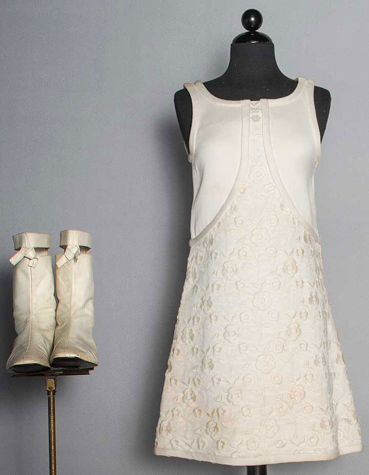 COURREGES WHITE MINI DRESS & BOOTS, MID 1960s: Heavy white cotton dress covered in floral embroidered net, sleeveless, unlabeled, B 32", H 36", L 34", (dirty, several large brown stains) fair; white leather low heel boots, square toe, back zipper,