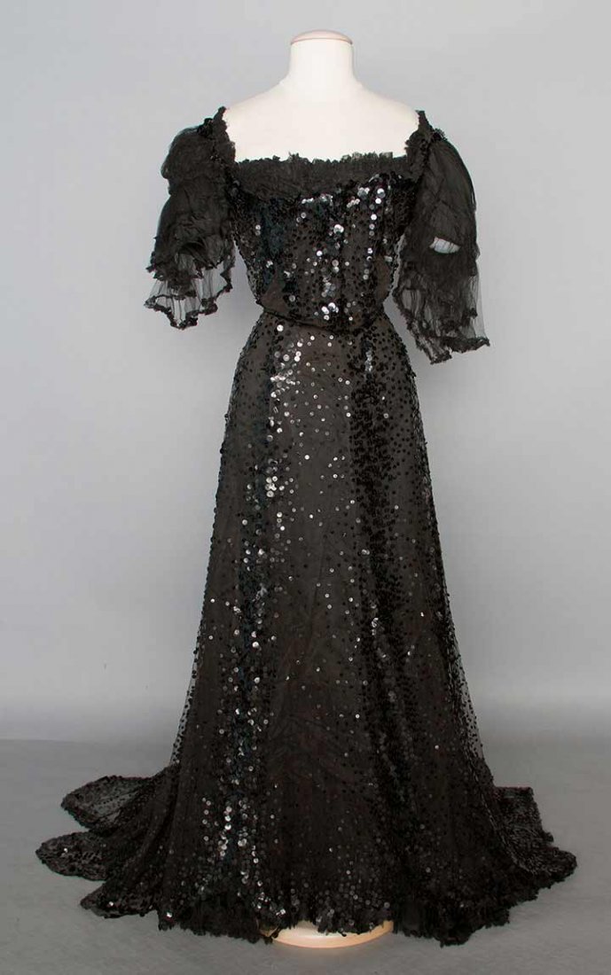 SEQUINED BELLE EPOQUE GOWN, c. 1904: 2-piece, black silk tulle covered in several sizes of black sequins, flounced short sleeves on bodice, trained skirt, both pieces lined in black silk, B 34", W 23", Skirt L 41"-58", (sequin losses, te