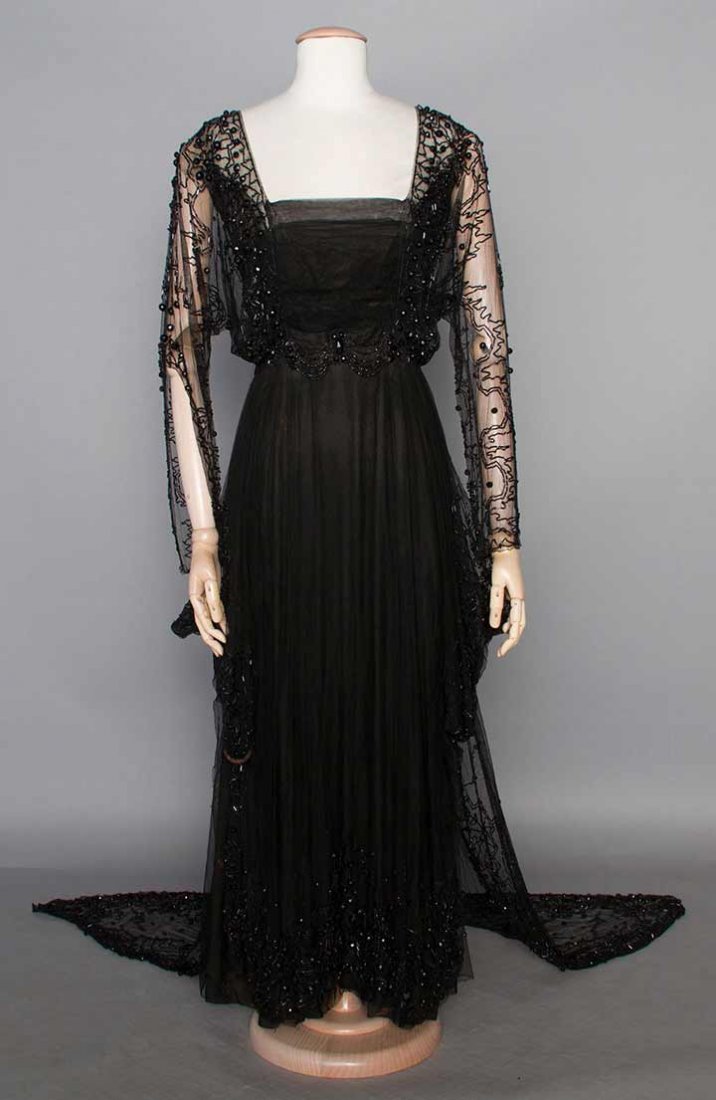 EDWARDIAN BALL GOWN, c. 1912: 1-piece, black silk net, trimmed w/ jet beads, long train attached to skirt, petersham labeled "Farquharson & Wheelock 724 Fifth Ave NY", B 34", W 24", L 53"-66", (missing hooks & eyes, minor holes in