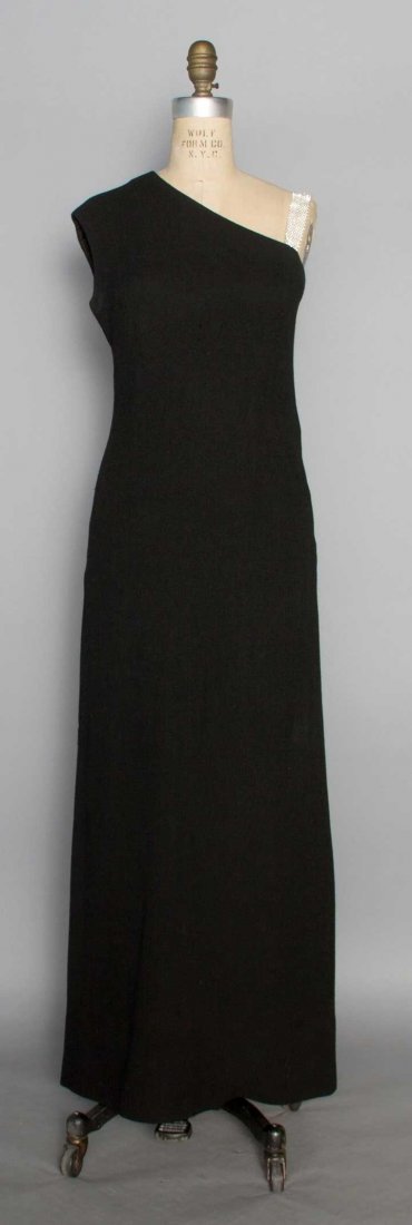 NORMAN NORELL EVENING GOWN, 1960s: Woven black wool long sheath, single shoulder, Swarovski crystal shoulder band (removable), black silk lining, low gathered panel at CB, labeled "Norman Norell New York" & inked on silk label "2192-16