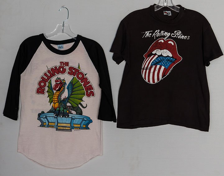 TWO ROLLING STONES TOUR T-SHIRTS, 1981: Both marked on F "The Rolling Stones": 1 black w/ F illustration of iconic red lips & US flag tongue & B w/ "The Stones North American Tour 1981" & Brittish flag, (torn & faded) fair; 1 white w/ black