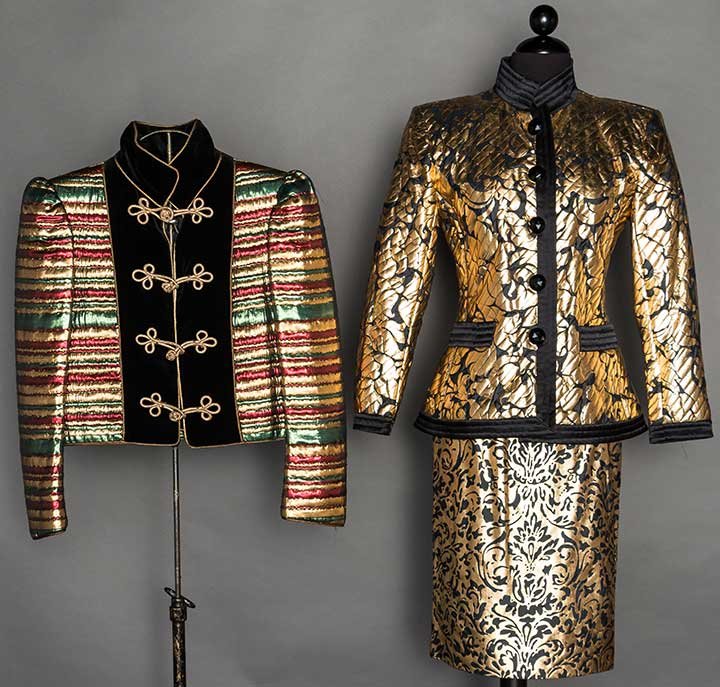 SAINT LAURENT JACKET & SKIRT SUIT, 1980s: Both labeled & marked FR size 34: 1 black silk w/ painted gold Rennaissance print skirt suit, fitted jacket, black channel quilted high band collar & trim, jet buttons, straight skirt; 1 lame cropped 