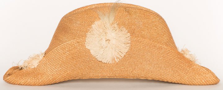 LITTLE BOY'S NAUTICAL STRAW HAT, 1870-1890: Natural straw braid in bi-corn shape, feather cockade, creased crown, silk lining stamped " , " x ", excellent.