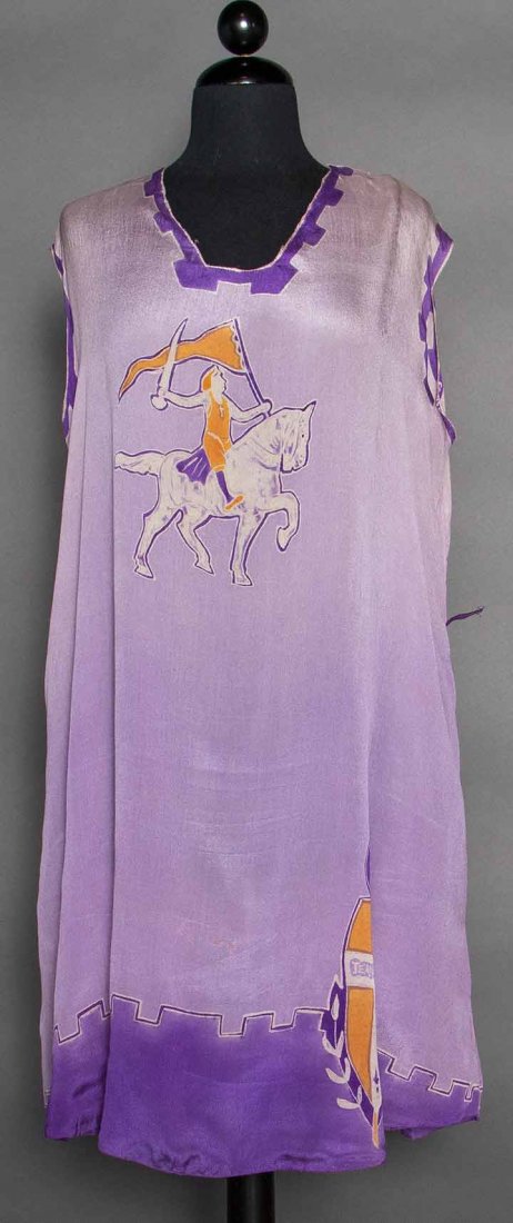 JEANNE D'ARC PRINT DRESS, 1920s: Lilac silk loose shift, sleeveless, square neckline, CF print of woman on horse, purple & gold printed heraldic emblem at hem w/ "Jeanne D'Arc" lettering in center white cross, armhole edge print "Col