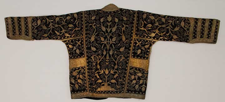 GOLD EMBROIDERED MAN'S COAT, MIDDLE EAST: Black wool broadcloth, gold metallic couched embroidery in twining vines & flower patterns, green wool lining, 2 interior shield shape pockets w/ gold embroidery, CH to 50", L 26", (tarnished in many 