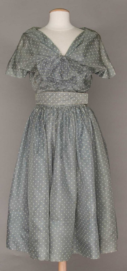 CHRISTIAN DIOR PARTY DRESS, MID 1950s: Light blue grey silk organdy, V neck suplice bodice w/ jabot, cap sleeves cut in 1 w/ bodice, full gathered skirt, silk linings, matching silk & leather belt, blue grey silk petticoat w/ orchid silk C