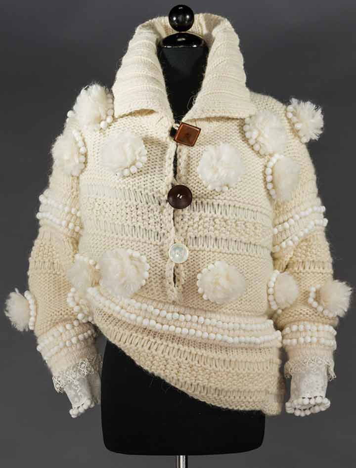 JOHN GALLIANO HAND-KNIT WHITE SWEATER: Wool, polyester & alpaca blend, fold down collar, 3 large & different placket buttons, over-size pom-pom trim, diagonal hem, IT size S, excellent.