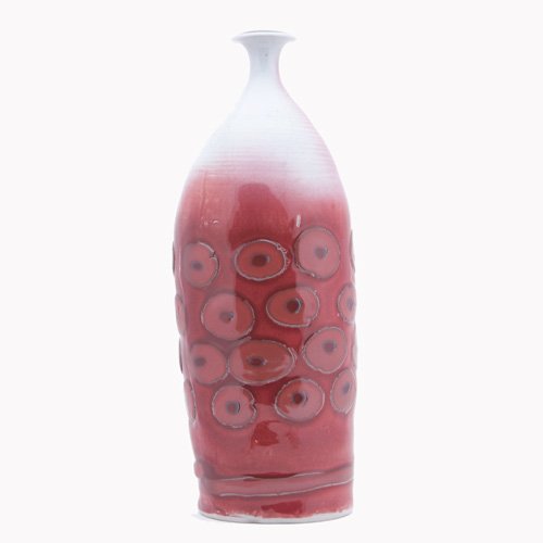 ADRIAN SAXE Tall porcelain bottle patterned with: ADRIAN SAXE Tall porcelain bottle patterned with circles under oxblood glaze. Signed SAXE. 19 1/2" x 7"