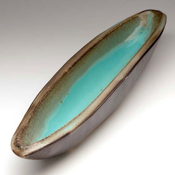 RUSSEL WRIGHT Long boat-shaped vessel covered in: RUSSEL WRIGHT Long boat-shaped vessel covered in turquoise and deep plum glaze. Stamped script signature. 3" x 25"