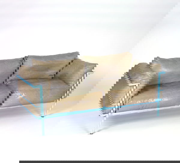 LE CORBUSIER Pair of settees (one shown), each wit: LE CORBUSIER Pair of settees (one shown), each with even-arm enameled metal frame in powder blue, nylon webbed seat support, and loose cushions covered in olive green leather. Some stains and discolor