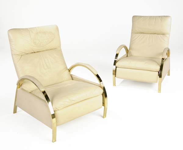 DESIGN INSTITUTE AMERICA Pair of recliners upholst: DESIGN INSTITUTE AMERICA Pair of recliners upholstered in cream-colored vinyl on polished brass frames, 1989. DIA metal tag. 40 1/2" x 29 1/2" x 34 1/2"