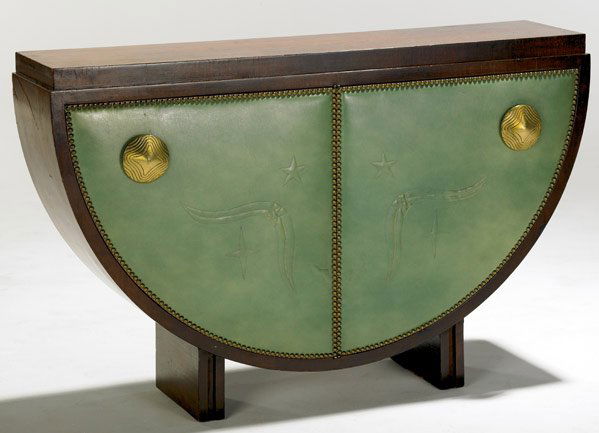 GILBERT ROHDE Semi-circular cabinet: GILBERT ROHDE Semi-circular cabinet with blue-green stitched leather door-fronts enclosing interior shelves, with brass hardware and tacks. 30" x 47" x 12"