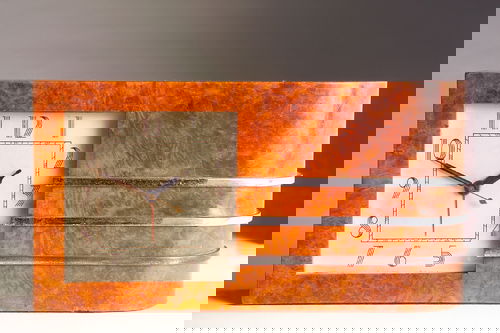 GILBERT ROHDE/HERMAN MILLER Art Deco "Telechron" e: GILBERT ROHDE/HERMAN MILLER Art Deco "Telechron" electric clock with burlwood veneer case, and three chrome bands. Herman Miller metal tag, also numbered 4082B. 6 3/4" x 13" x 2 3/4".