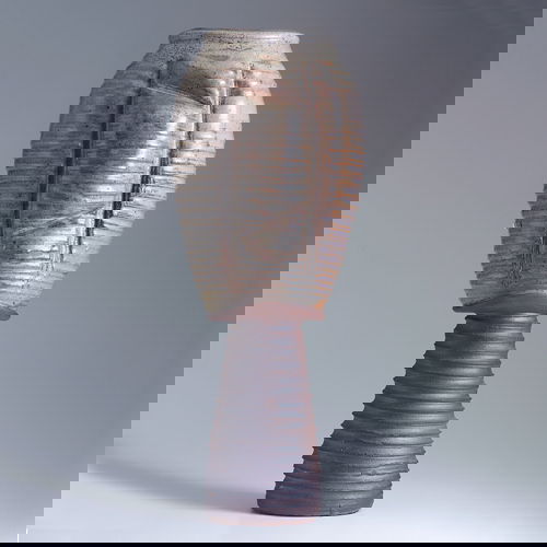 DON REITZ Stoneware footed vessel with horizontal: DON REITZ Stoneware footed vessel with horizontal throwing ridges and asymmetrical dimples covered in gray matte glaze over an iron oxide foot. Signed in marker "Don Reitz". 23 1/4" x 9".