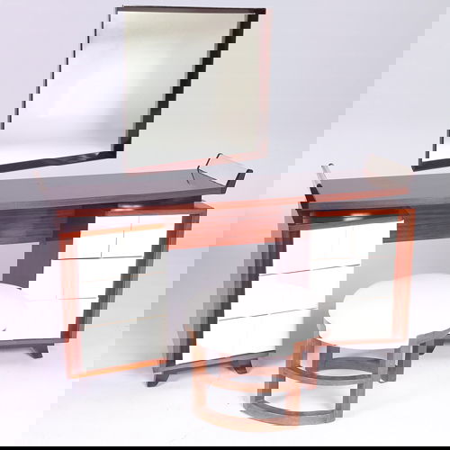 GILBERT ROHDE/HERMAN MILLER Three pieces: Six-dra: GILBERT ROHDE/HERMAN MILLER Three pieces: Six-drawer vanity with tufted white leatherette on ebonized wood legs; vanity stool with muslin upholstery; and square wall-hanging mirror. Unmarked. Vanity: