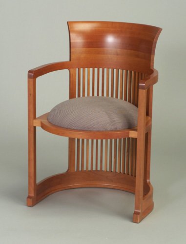 CASSINA cherry wood Barrel chair after a: CASSINA cherry wood Barrel chair after a design by FRANK LLOYD WRIGHT, with flared and spindled back, and gray fabric-upholstered circular seat pad. Cassina paper tag. 31 3/4" x 21 1/2" x 20 1/2"