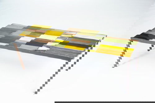 ROGER CAPRON Coffee table, its top with geometrica: ROGER CAPRON Coffee table, its top with geometrically-shaped tiles covered in ochre, green, brown, black, and ivory crackled glazes, on black iron base. Artist-signed. 15 1/2" x 47 3/4" x 16"