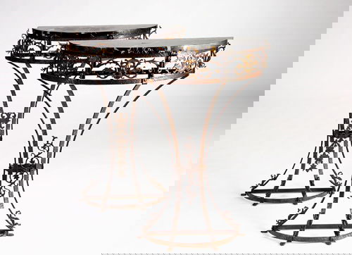 OSCAR BACH Pair of fine wrought-iron demi-lune con: OSCAR BACH Pair of fine wrought-iron demi-lune console tables with black marble tops, and Renaissance mask motif to reticulated aprons. Unmarked. 34" x 25 1/2" x 11"