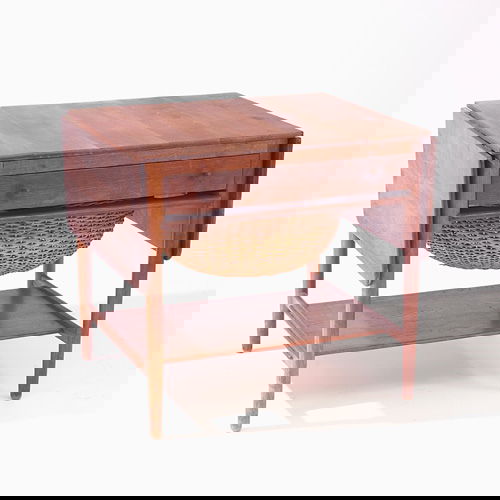 HANS WEGNER Drop-leaf sewing table with single dr: HANS WEGNER Drop-leaf sewing table with single drawer, wicker basket, and lower shelf. Finish wear, and separations to top. 24" x 25" x 22"