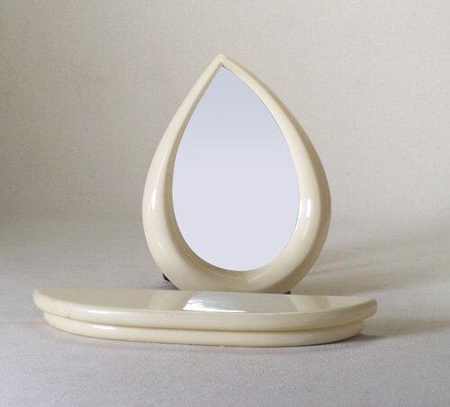 KARL SPRINGER Wall-hanging console and t: KARL SPRINGER Wall-hanging console and tear-shaped mirror in cream-colored enameled wood. Some minor losses. Unmarked. Mirror: 36" x 27, shelf: 45" x 12"