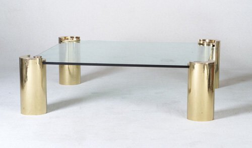 KARL SPRINGER Coffee table with recessed: KARL SPRINGER Coffee table with recessed plate glass top on four cylindrical brass legs. Chips to corners of glass. Unmarked. 17" x 59" sq.