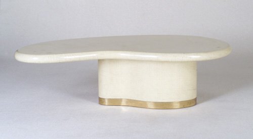 KARL SPRINGER Coffee table with amoeba-s: KARL SPRINGER Coffee table with amoeba-shaped top, asymmetrically-placed on a conforming pedestal base with brass trim, covered in an ivory and brown lacquered finish. Unmarked. 17 1/4" x 59" x 34"