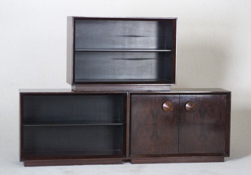 GILBERT ROHDE HERMAN MILLER Paldao three: GILBERT ROHDE HERMAN MILLER Paldao three-piece cabinet/bookcase with two open single shelf units flanking a two-door cabinet with large conical carved wood pulls, and single interior shelf. Stenciled