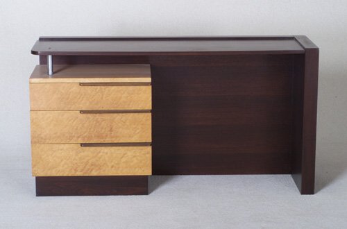 GILBERT ROHDE Fine HERMAN MILLER single-: GILBERT ROHDE Fine HERMAN MILLER single-pedestal desk with raised rectangular frame over bank of three drawers with horizontal off-center pulls and bird's eye maple veneer drawer fronts. Missing glass