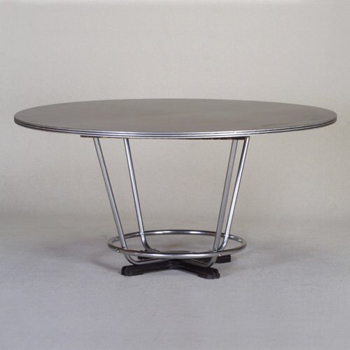WOLFGANG HOFFMANN: HOWELL circular dining table with layered black laminate top on tubular chrome support mounted in a cast-iron base. Howell decal. 29 1/4" x 60 dia.