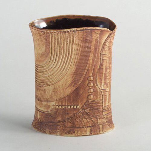 BERTIL VALLIEN: RORSTRAND porcelain pillow vase with raised and excised decoration covered in mottled brown and tan matte glaze with simulated leather appearance. Marked "Rorstrand" with crowns/Sweden/B. Vallien. 9 1