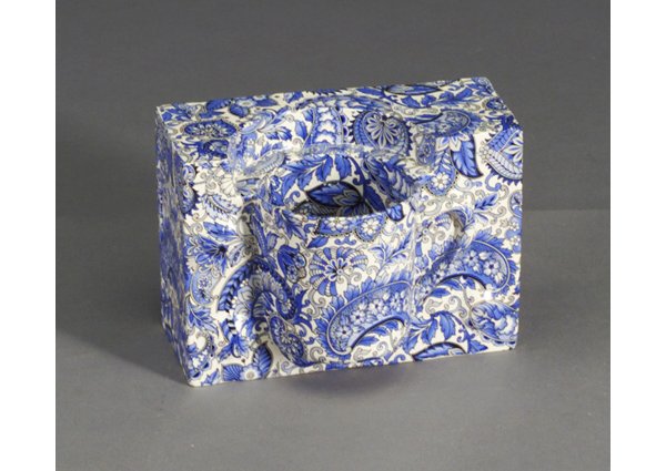 HOWARD KOTTLER earthenware sculpture, "P: HOWARD KOTTLER earthenware sculpture, "Paisley Cup", 1973, depicting a coffee cup embedded in a rectangular block, with blue paisley decal decoration. (Provenance: Garth Clark Gallery, also illustrate