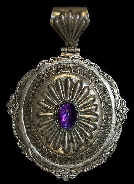 Navajo sterling amethyst concho pendant: Vintage Navajo sterling concho pendant with traditional Diné design set with a gem quality amethyst cabochon, extensive repoussé and stamp-work, measuring 4.5" x 3.25" artist signed "H. Ration"
