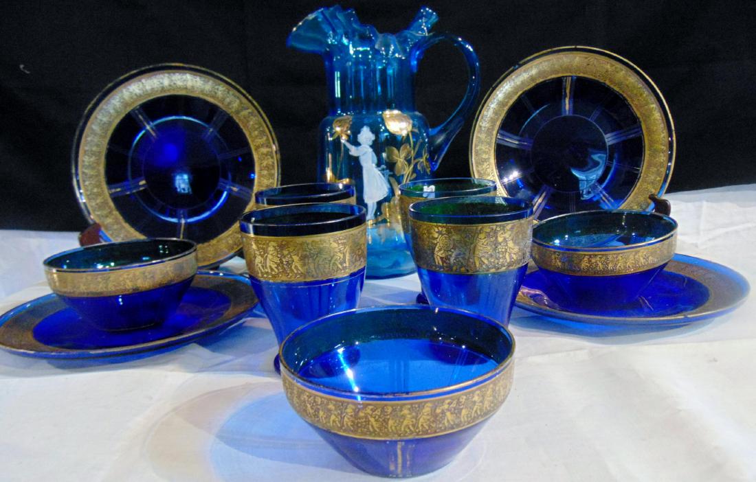 Cobalt Luncheon Set & Mary Gregory Art Glass Pitcher: Cobalt luncheon set for 4, with acid cut back Grecian soldiers gold overlay decoration, includes: 4 plates, 4 tumblers, 3 fruit bowls, all in good condition; along with a Mary Gregory art glass pitche