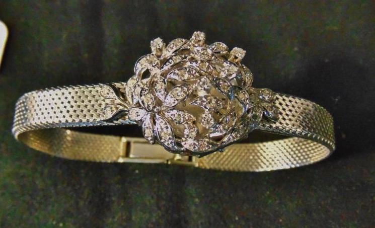 18K White Gold Ladies Watch: Stunning 18K White Gold Ladies Watch profusely Diamond studded Leaf decorated cover that opens to reveal an Omega Watch. This Outstanding Custom Ladies watch is of the Highest Quality. It's weight wit