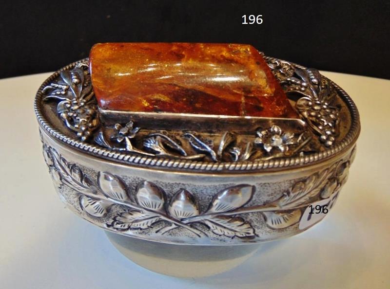 Sterling Silver Box with Large Amber: A Sterling Silver Box Hand Chased Hinged Lidded Box with an Immense Piece of Natural Amber. The Sterling Lid features a Deep 3-dimensional relief of Flowers. Overall Box measurements are 2.25"Tx4.25"W