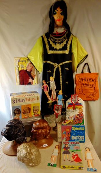 TV Memorbilia: Lot of TV movie and Halloween toys and costumes to include Bewitched card game, 3 children's play wigs, Lily Muster halloween costume and mask, Gay Dolls paper dolls, 3 Tin Lithograph noisemakers, Jan