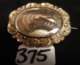 Victorian Momento Mori Mourning Hair Brooch: This Victorian momento mori Mourning Brooch features a lock of the dearly departed's hair under glass surrounded by a gold Filigreed setting. It can also be used as a pendant and measures 1" tall x 1.