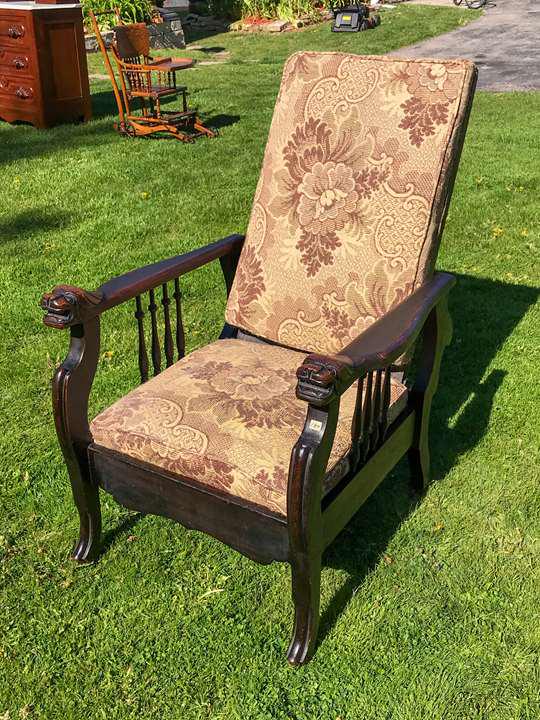 Cook& CO Automatic Reclining Chair w/Lion Armrests C.: This Cook and Co. Automatic turn of the Century oak reclining chair has hand carved arms featuring snarling lion's faces and spindled sides. It is upholstered in a floral and scrolled fabric. There is
