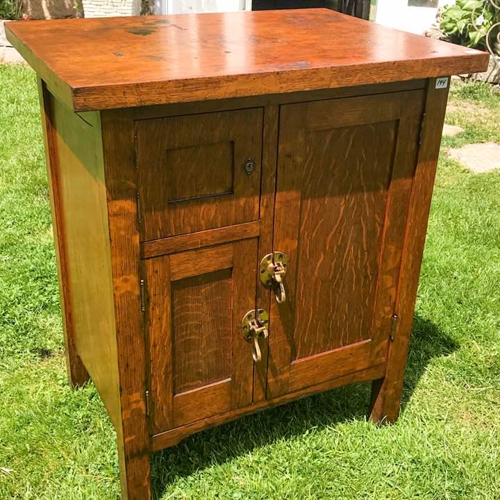 Arts and Crafts/ MIssion Oak Liquor Cabinet: This Arts and Crafts/Mission oak 3 door liquor cabinet is quartersawn oak and has the original brass latches. Top has stains. It measures 30" tall X 25" across X 19" deep.
