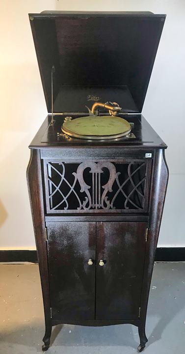 Wilbur Victrola of Waukesha WI, in working condition: This Wilbur Victrola is from Waukesha Wisconsin and is in a mahogany case. It has a fancy fretwork over the speaker, and serpentine knees. On casters, it measures 63" tall (open) X 21" across X 23" de