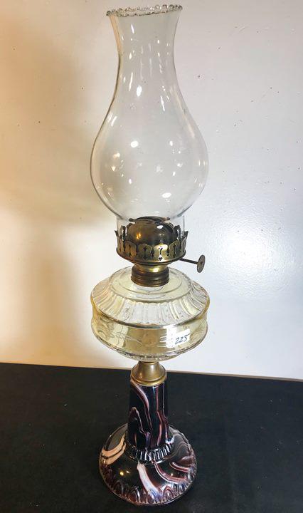 Slag Glass Base Oil Olamp c1910: This Slag glass pedestaled oil lamp circa 1910 has an etched fount and an Eagle Burner. It meaures 22.5" tall X 6' across. Small crack in chimney noted.