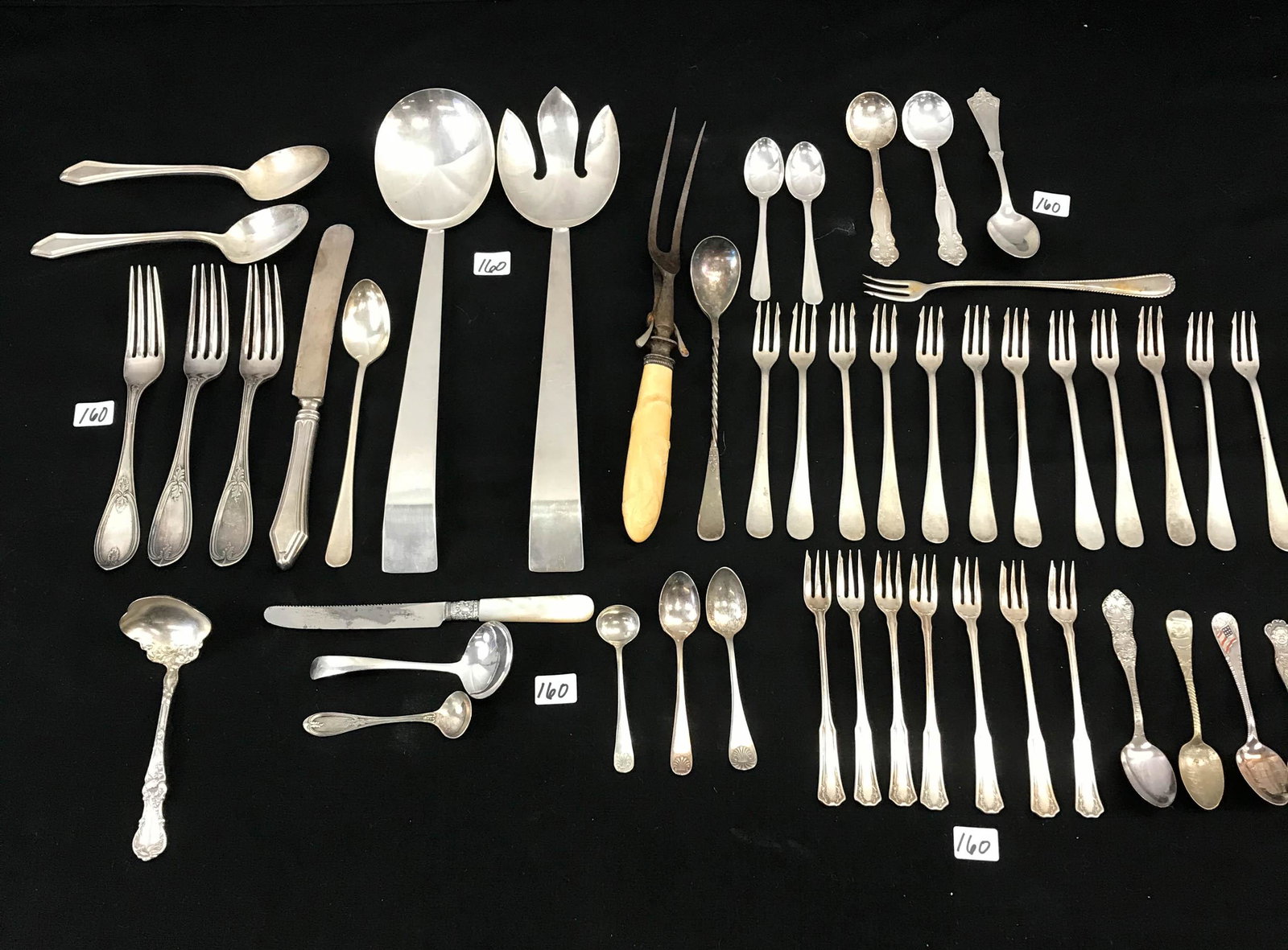 Large mixed Group of Quality Flatware: This large mixed group of quality silverplated flatware includes a Remember the Maine souvenir spoon, Milwaukee Post office spoon, 2 large MCM salad tossers, a Victorian meat fork with a hand carved b