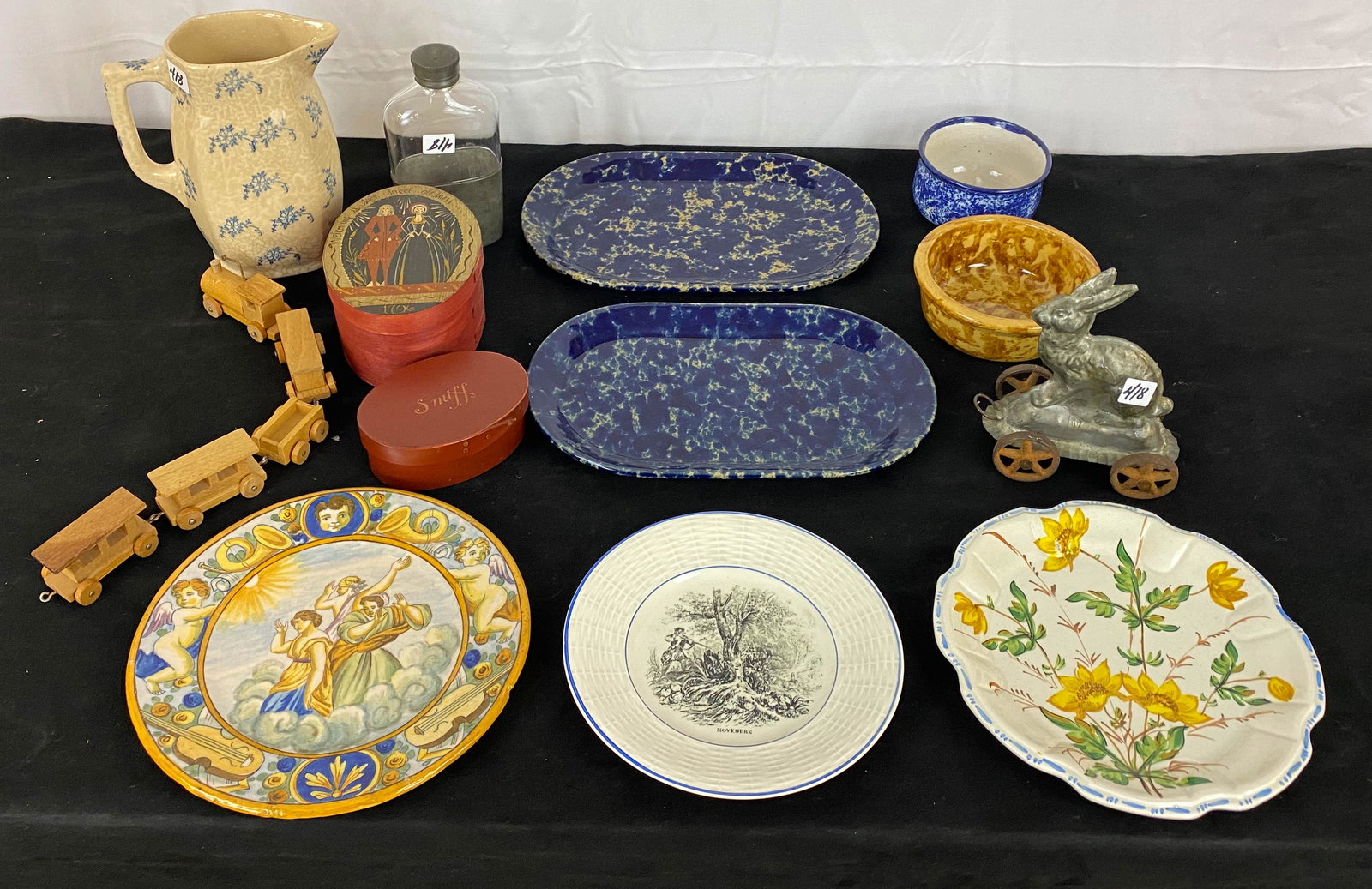 Lot of Primitives to Include Spongeware, Flask, and: A primitive lot to include early liquor bottle, plates, spongeware, a rabbit mould on wheels, two pantry boxes, and more.