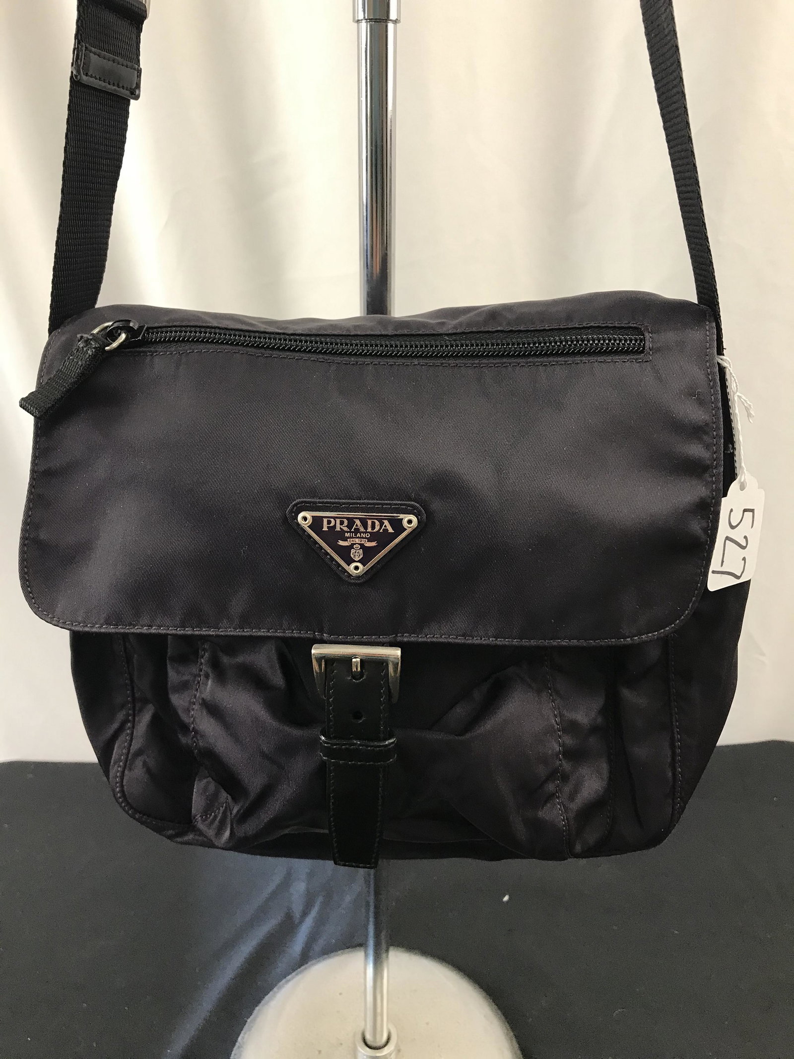 Prada Black Tesasuto Shoulder Bag: This black Prada Tessuto shoulder bag has an outside closing flap with a buckle closure, adjustable shoulder strap, and a zip pocket. There is a zip pouch under the flap, and an interior with another 