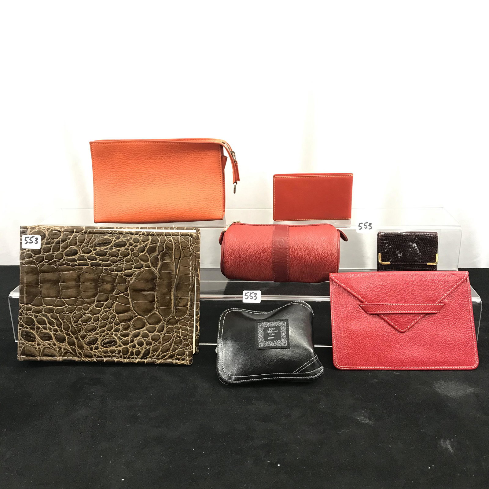Group of Designer Leather Accessories: This group of designer leather accessories include a Trussardi red leather zippered barrel pouch (4" tall X 6" across), an orange leather small zippered bag by Trisha McEvoy (5" tall X 7" across), an