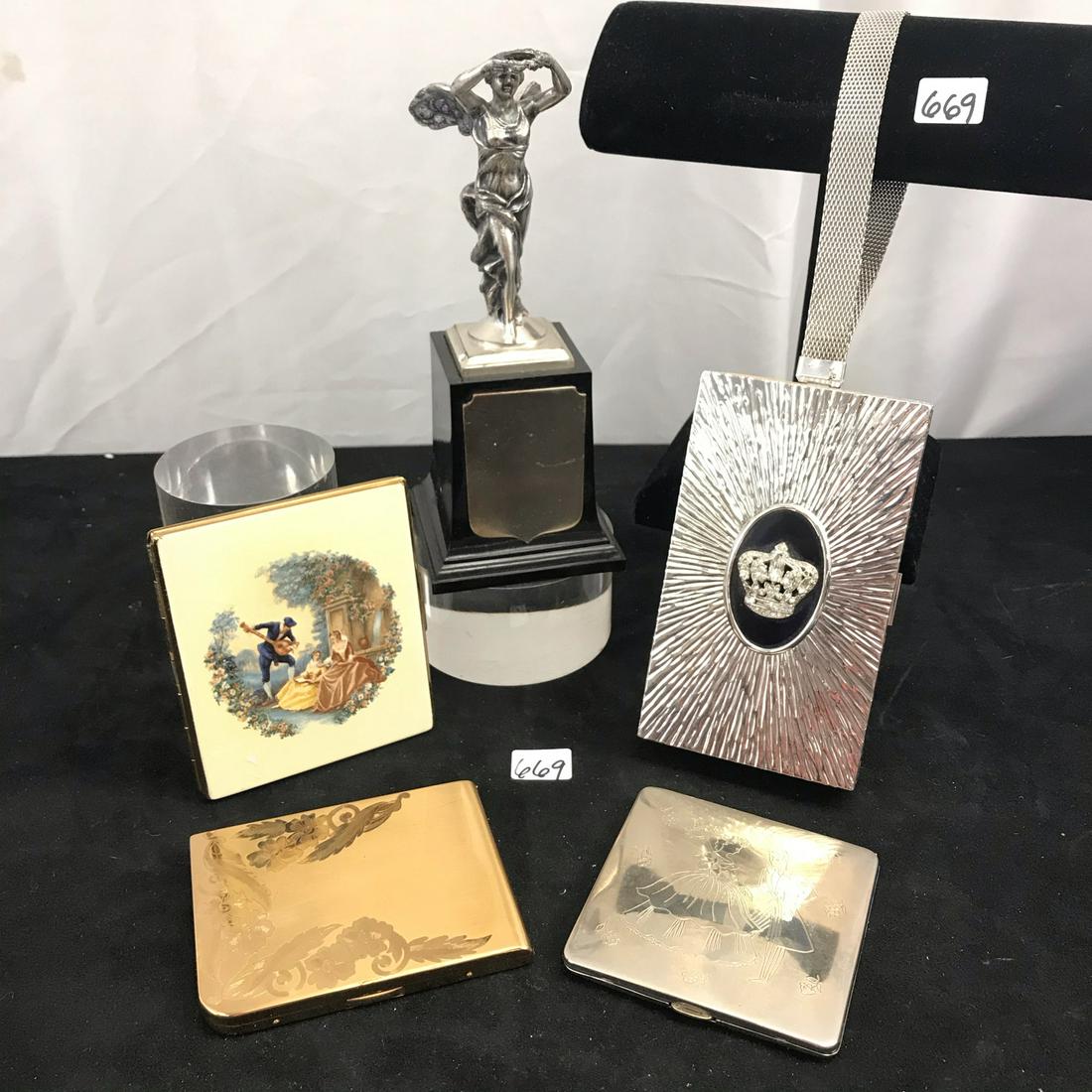 Group of Cigarette Cases and Compacts: Tis group of 40's and 50's cigarette cases include a silver Evand wristlet that has a cigarette case in one compartment, and a mirror, comb, lipstick and mirror compact on the other. There is a rhines
